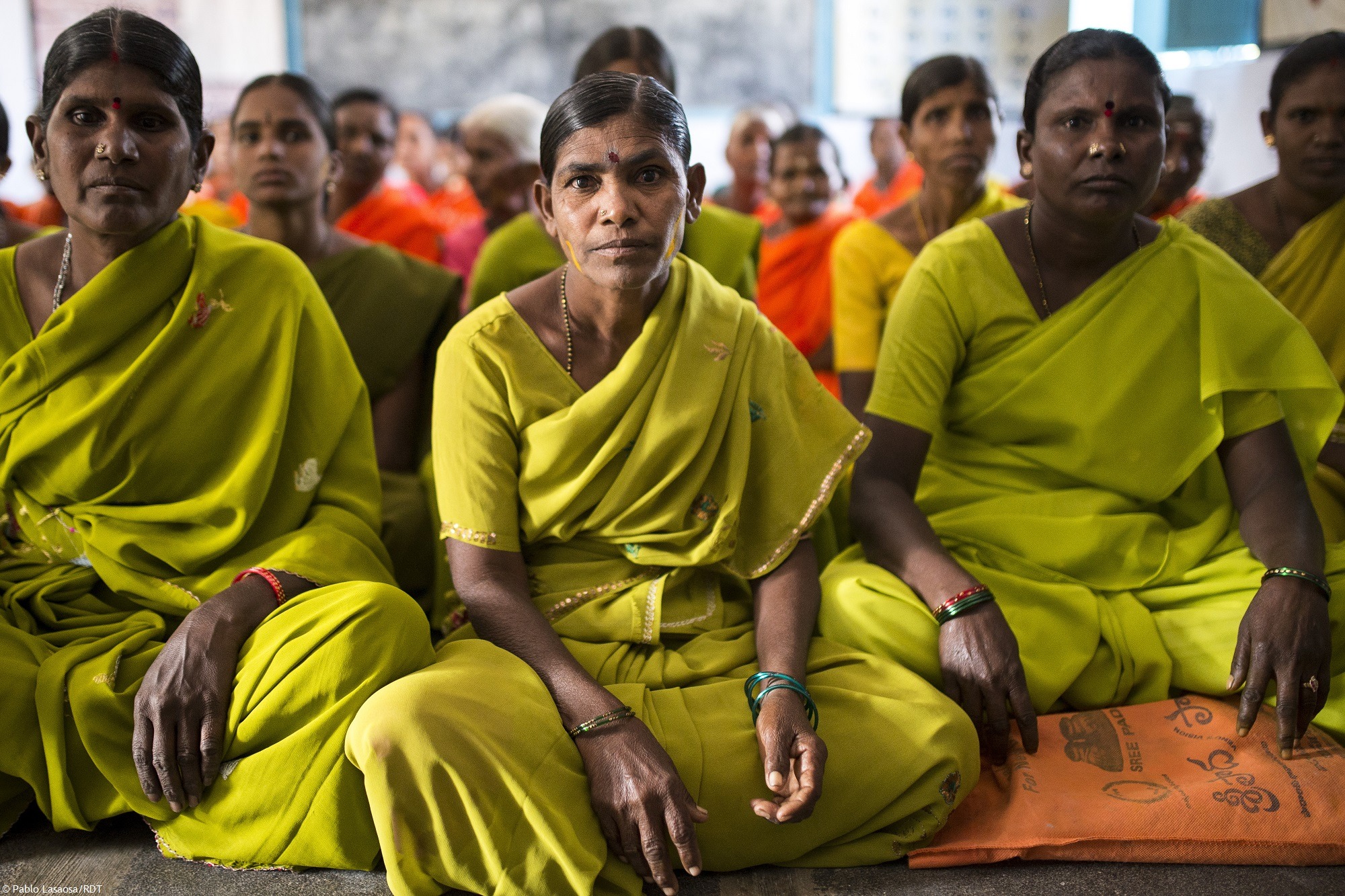 Frauen in grünem Sari versammlen sich im Sangham in Indien