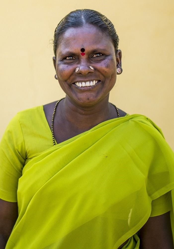 Frau in Indien mit grünem Sari lächelt in die Kamera