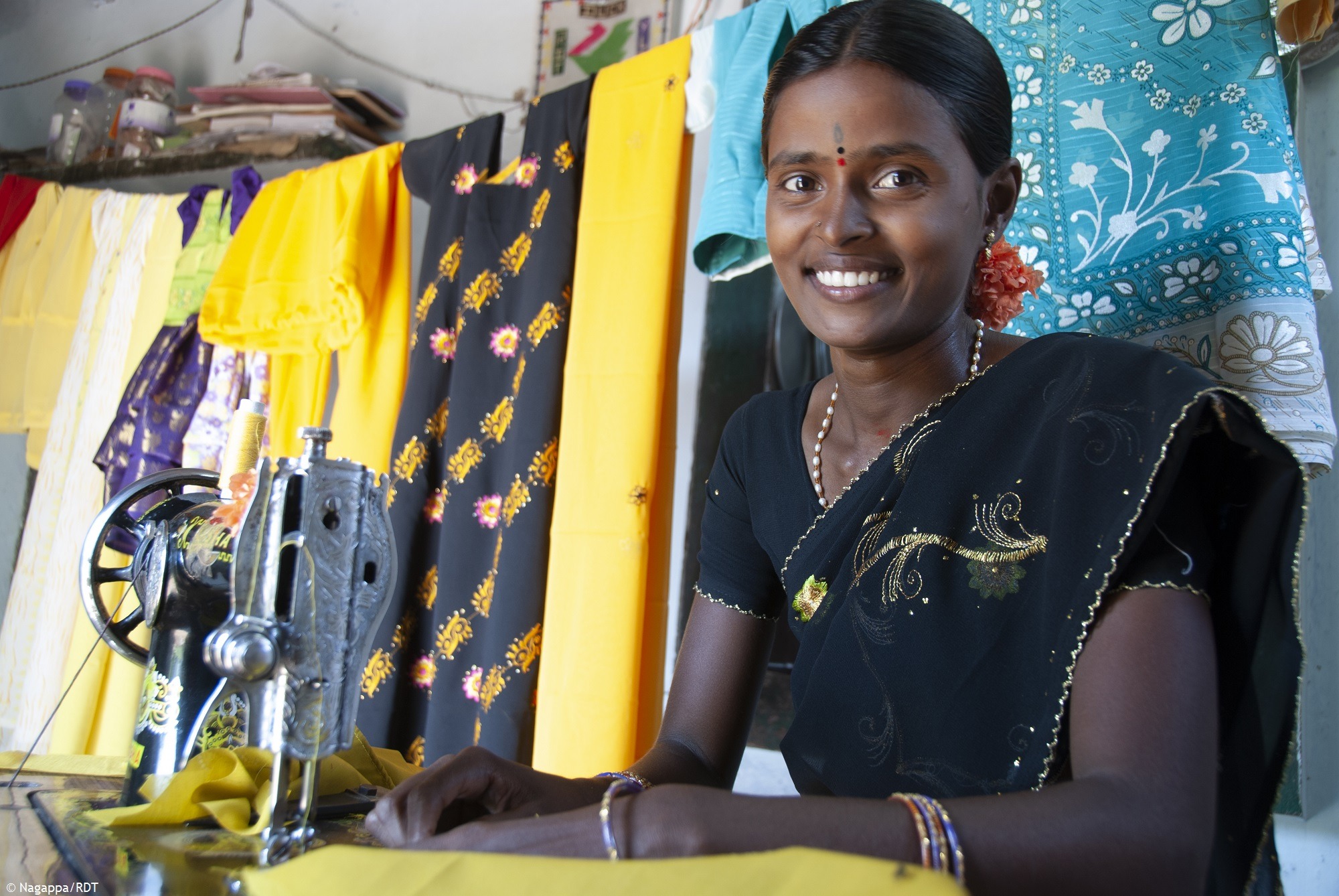 Indische Frau an der Nähmaschine. Indische Frauen stärken und finanzielle Unabhängigkeit ermöglichen