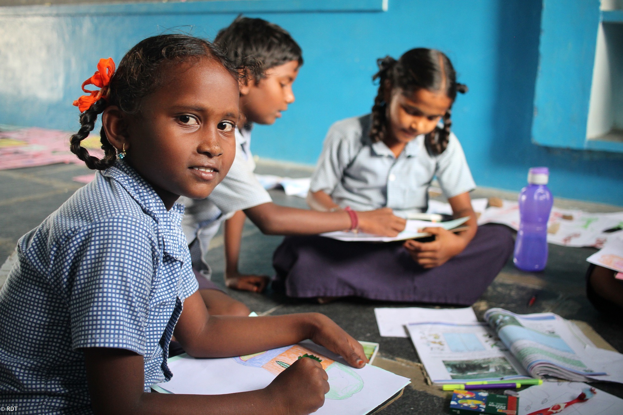 Schulkinder in Indien sitzen in der Schule mit Schulheften. Alphabetisierung in Indien mit Stiftungsschulen fördern.